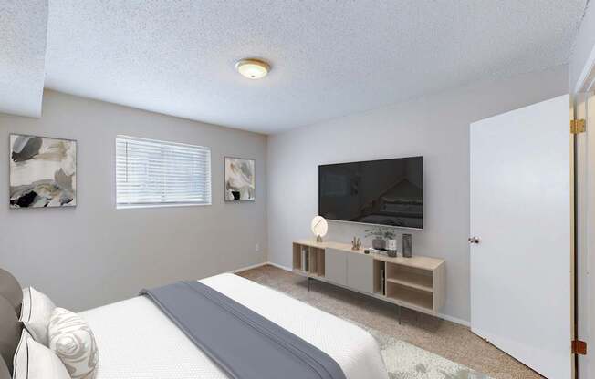 A bedroom with a bed, a television, and a window.