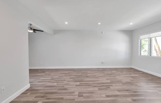 A room with wooden flooring and white walls.
