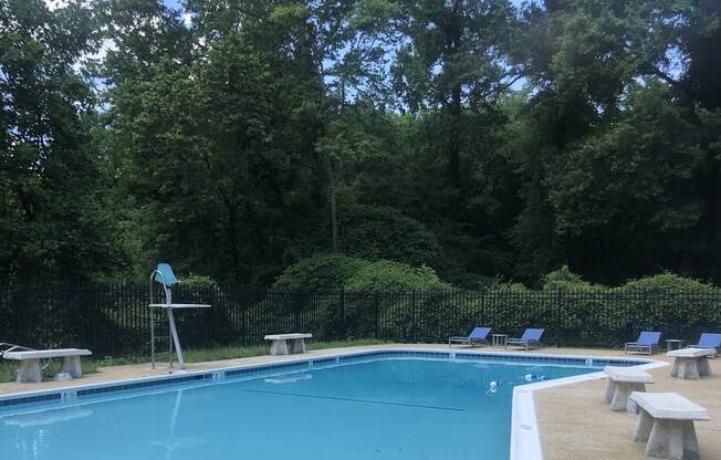 A pool with a diving board and a metal ladder. at New Carrollton Woods, Riverdale, MD