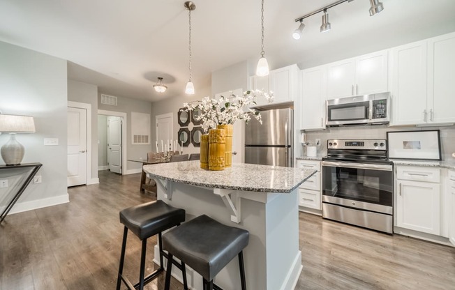 a kitchen with stainless steel appliances and a marble counter top