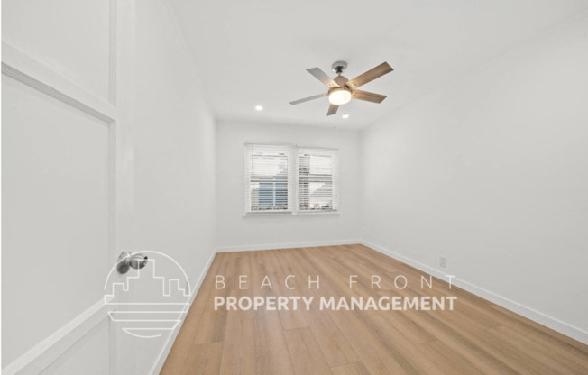 a white room with a ceiling fan and a window