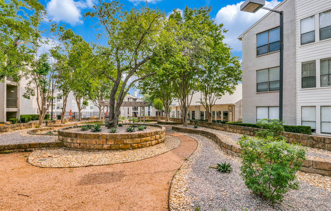 a courtyard between two buildings with trees and plants