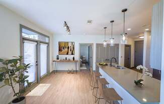 A kitchen with a long counter and bar stools.