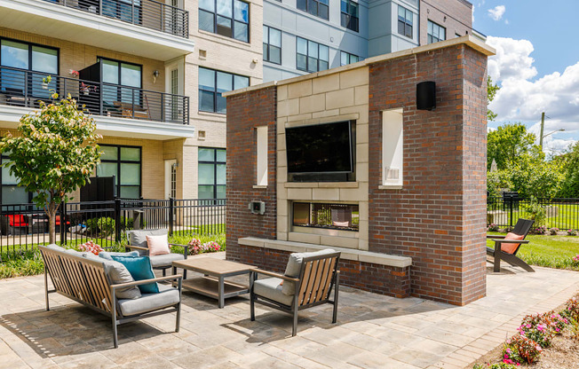 A patio with a brick fireplace and seating area.