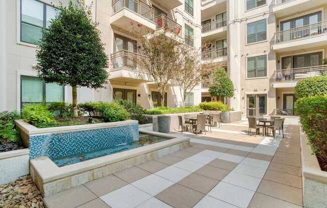 A large white building with a pool in the courtyard.