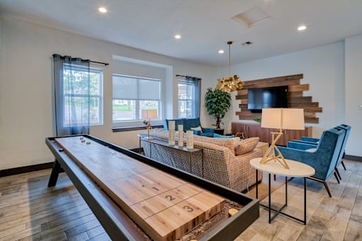 A shiny wooden table is in the middle of a room with a couch and chairs.
