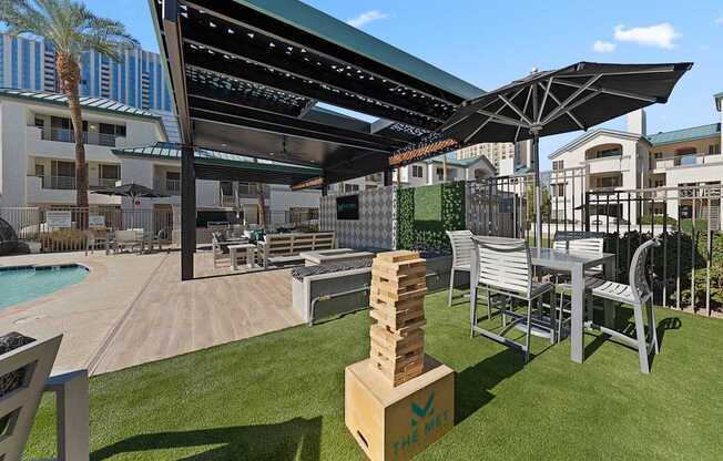 A patio area with a pool and a table and chairs.