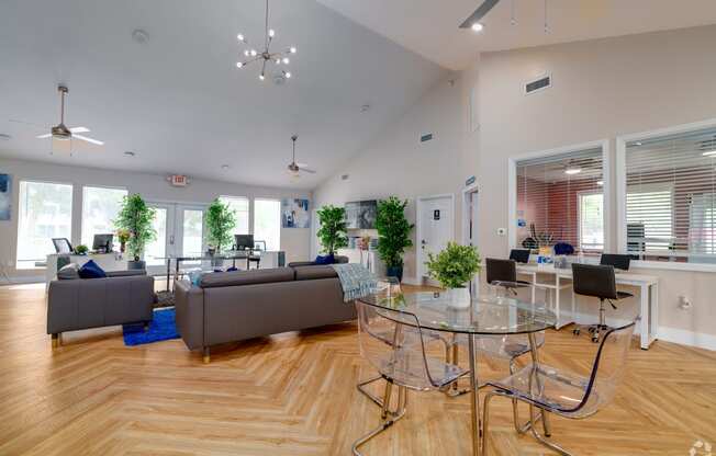 a living room with couches and a glass table and chairs