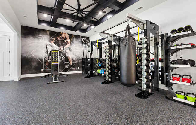 A gym with a punching bag, weights, and exercise equipment.