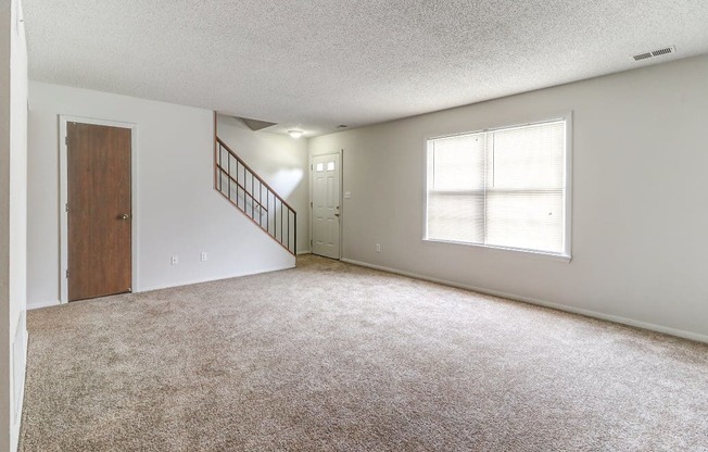 Townhome living room with access to the front door and stairs at Ashley Pointe Apartments