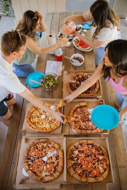 Residents eat pizza at a community event at Cranbrook.