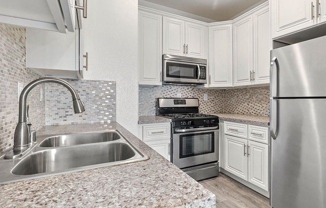 Kitchen with stainless steel fridge, oven, and microwave.