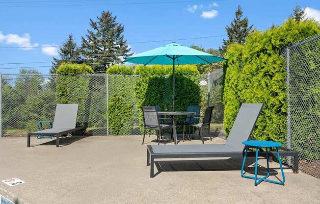A patio with a table, chairs, and an umbrella.