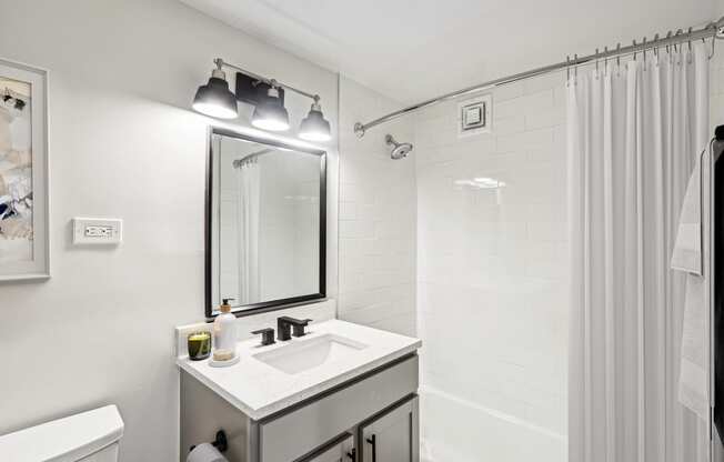 a bathroom with a sink and a shower and a mirror