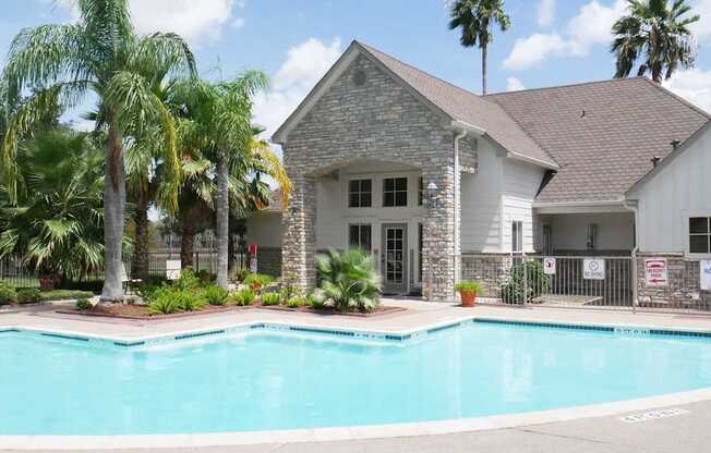 A house with a pool in front of it.