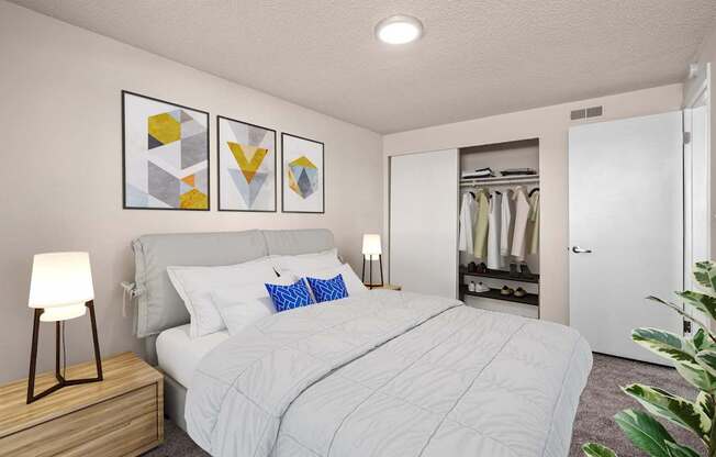 A bedroom with a large bed and a wooden nightstand.