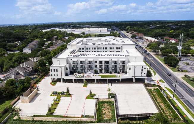 A large white building with a parking lot in front of it.