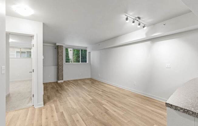 A room with wooden flooring and white walls.