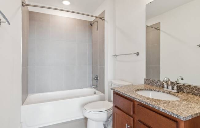 A white bathroom with a toilet, sink, and shower.