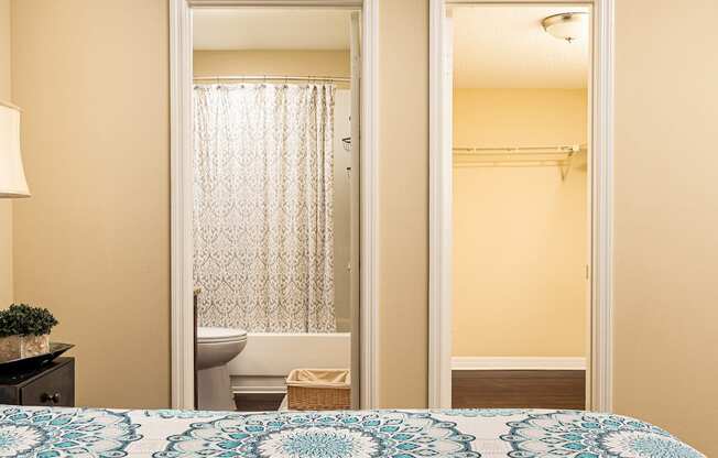 a bedroom door open to a bathroom with a toilet and a shower