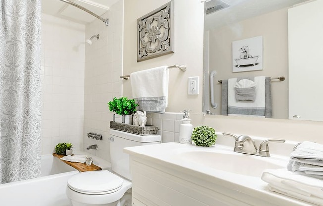 a white bathroom with a white toilet and tub and a white sink