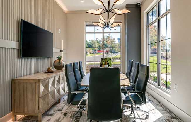 a conference room with a table and chairs and a tv