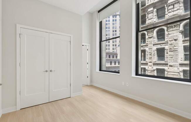 A room with a white door and a large window with a black and white picture on the wall.