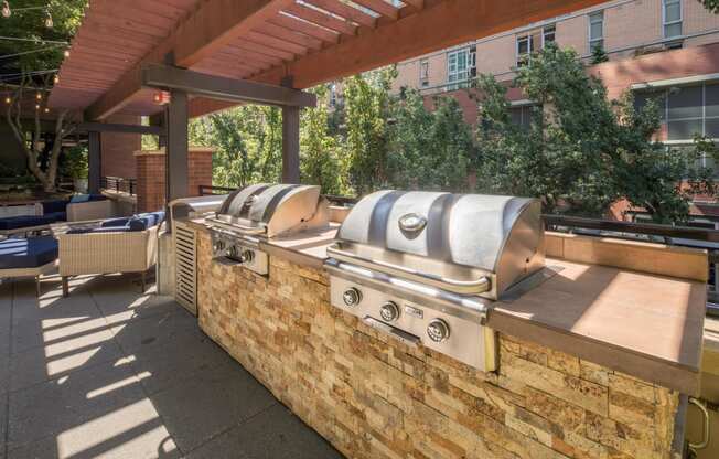a brick wall with two bbq grills and a pergola