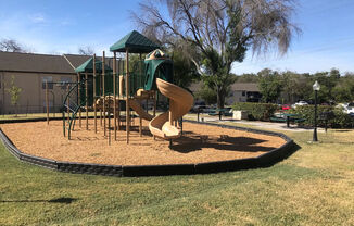 A playground with a slide and a green canopy.