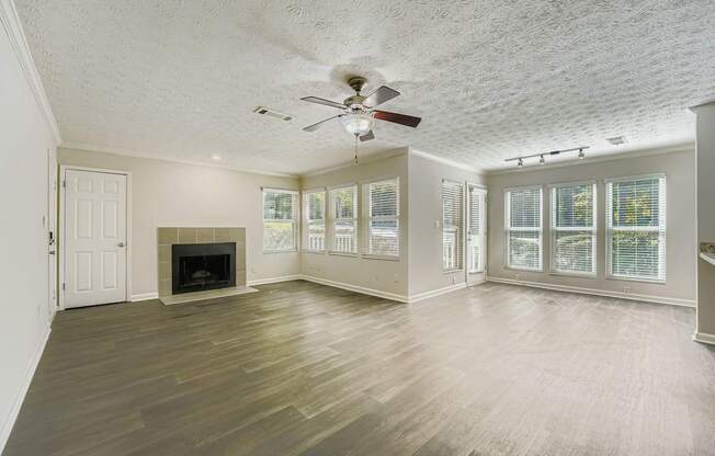A spacious room with a fireplace and a ceiling fan.
