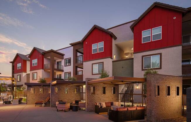 a group of townhomes with red and white facades at dusk at Weylyn Luxury Apartments, Laveen, AZ, 85339