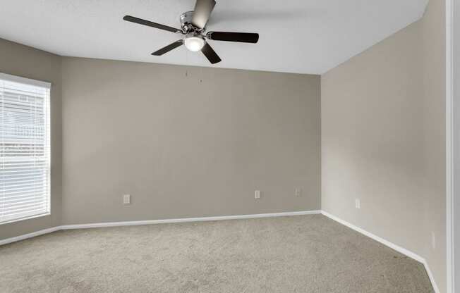 Spacious Carpeted Bedroom With Ceiling Fan