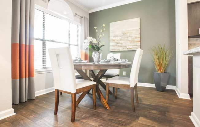 a dining room with a table and chairs and a window