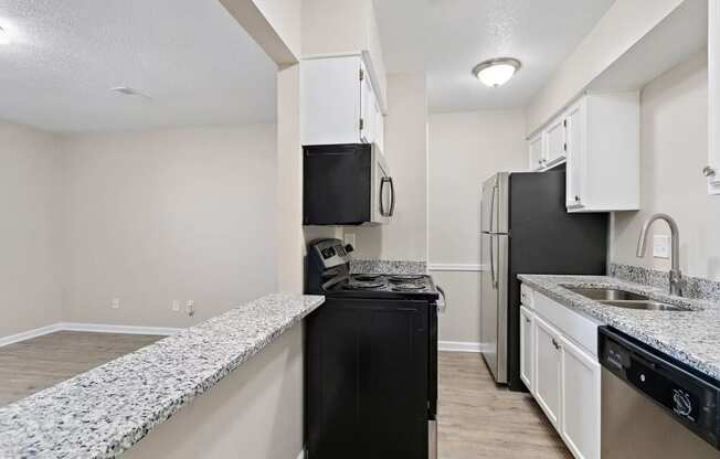 a kitchen with white cabinets and black appliances