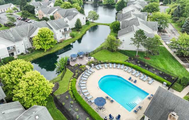 an aerial view of a resort style swimming pool with chaise lounge chairs and umbrellas