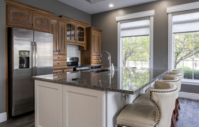 a kitchen with a large island with a granite countertop
