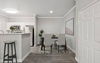 a dining room and kitchen area with a table and chairs