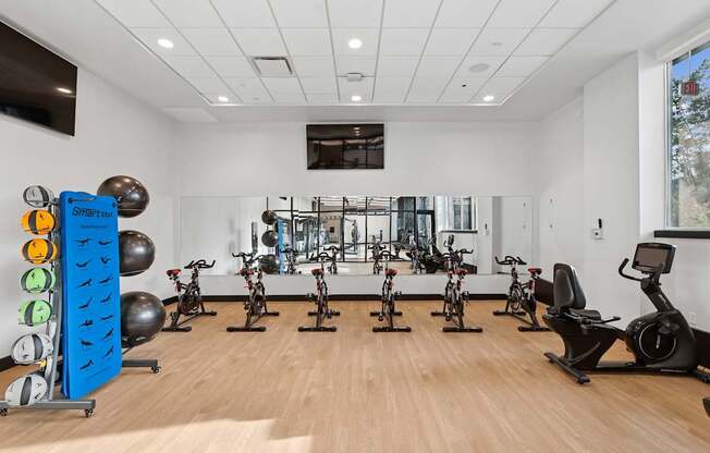 A gym with exercise equipment and a mirror on the wall.