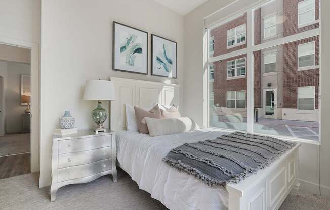 a bedroom with a bed and a large window