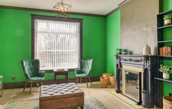 a living room with green walls and a fireplace
