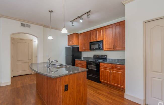 A kitchen with wooden cabinets and a granite countertop.
