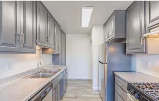 a kitchen with gray cabinets and white countertops