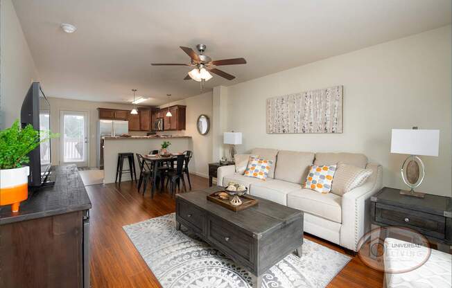 A living room with a white couch and a wooden coffee table.