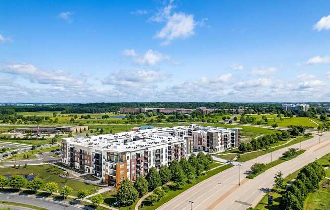 A large apartment complex with a parking lot in front.