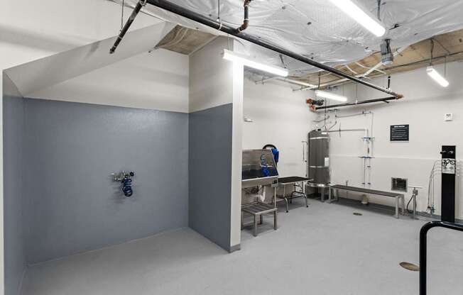 A room with a white floor and grey walls with a person in the background.