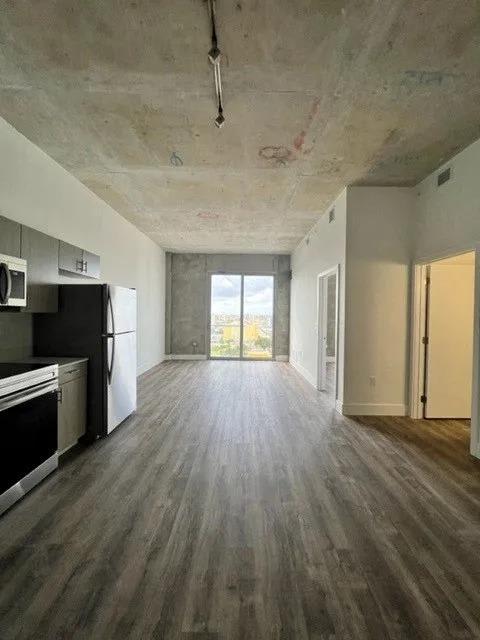 an empty room with a refrigerator and a stove in it