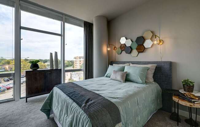 A bedroom with a large bed and a view of the city.
