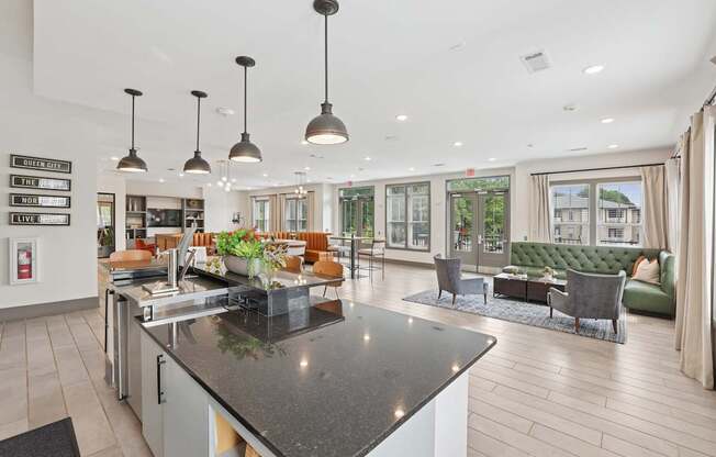 A modern kitchen with a black countertop and pendant lights.