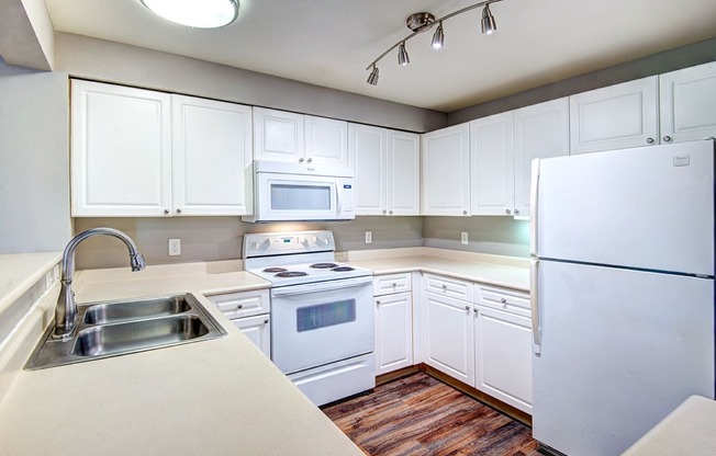 Two-bedroom apartments in Issaquah, WA - Langara - Fully Equipped Kitchen with White Appliances, White Cabinets, and Dual Sink