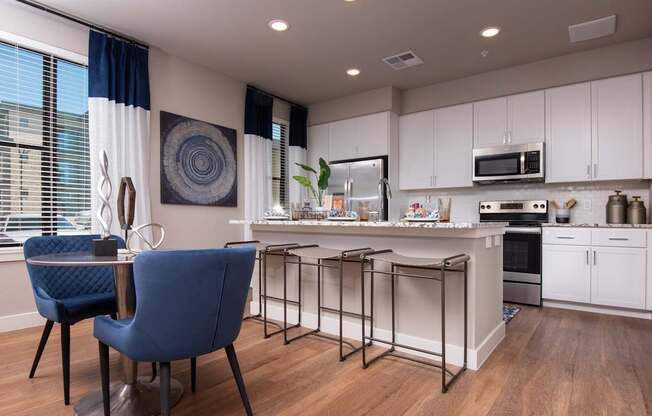 A blue chair sits in a kitchen with a white island and a fridge.